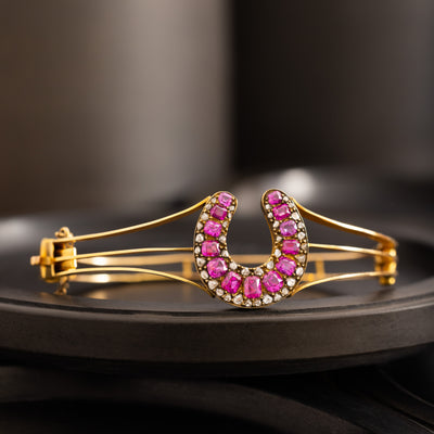 VINTAGE 18K YELLOW GOLD DIAMOND AND RUBY HORSESHOE BANGLE
