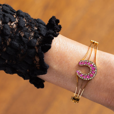 VINTAGE 18K YELLOW GOLD DIAMOND AND RUBY HORSESHOE BANGLE